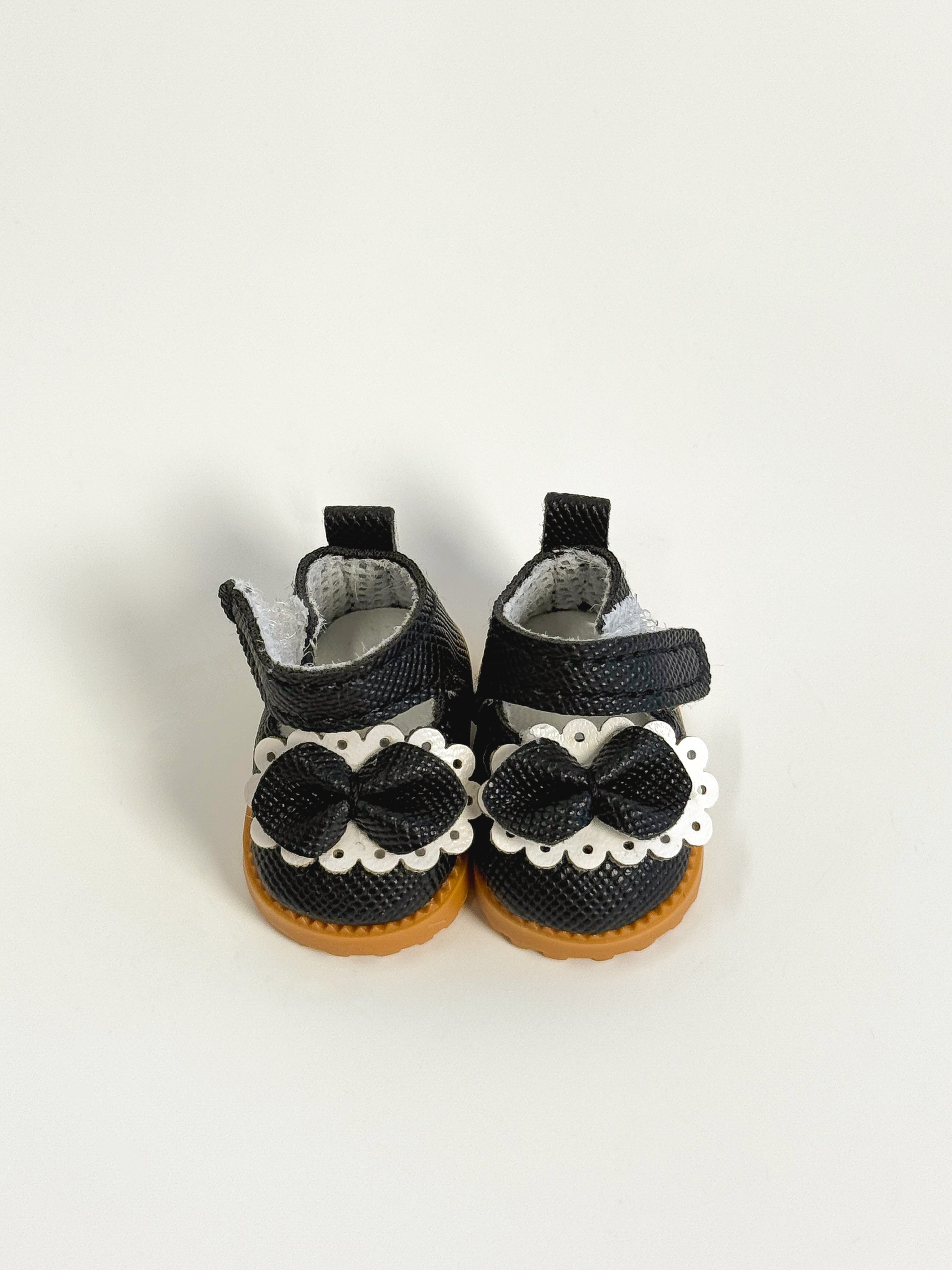 Pair of black baby shoes with white sequin bows on a light gray background
Labubu Shoes
Labubu Sneakers
Labubu Runners
Labubu Trainers
Labubu Miniature