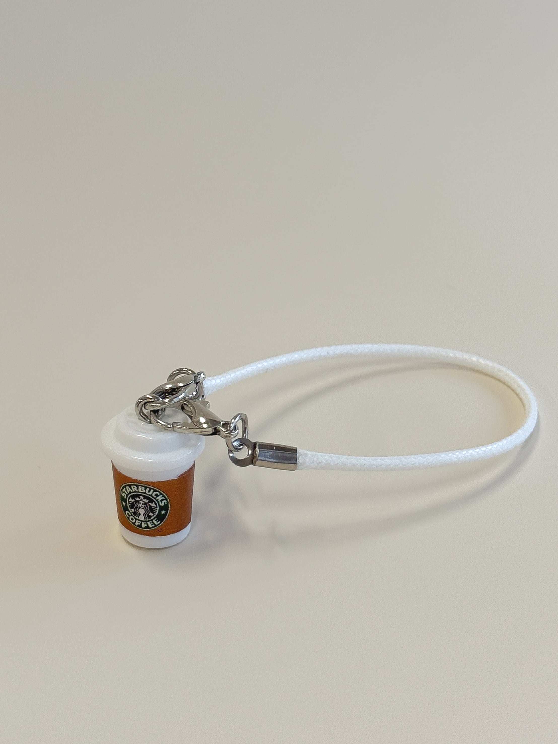 Starbucks cup keychain with white cord on a beige background
Labubu accessories
Labubu Starbucks accessories