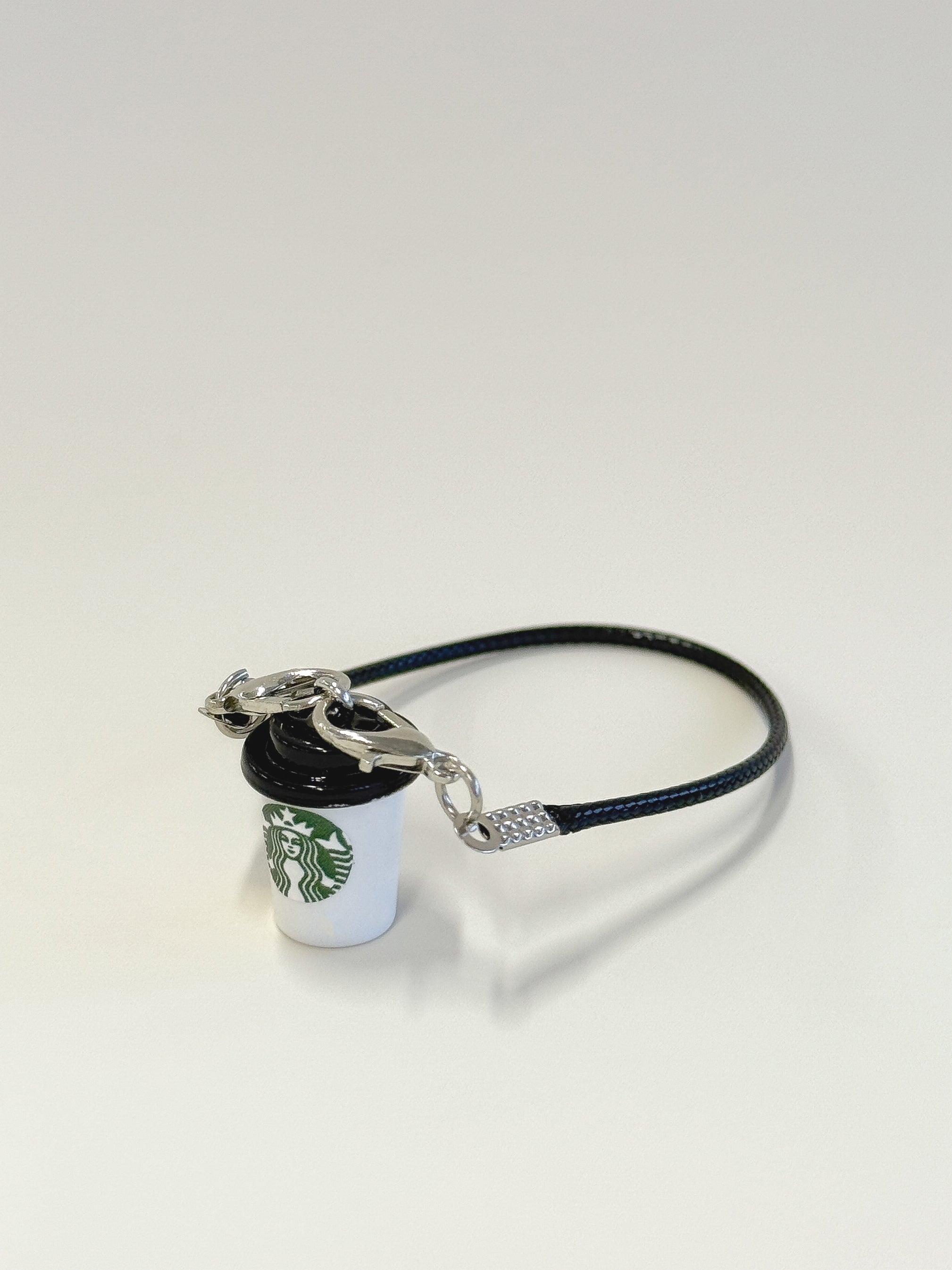 Starbucks cup-shaped keychain with black band on a white background
Labubu accessories
Labubu Starbucks accessories